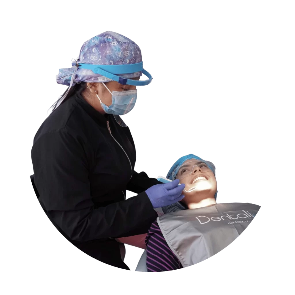 Dentista en Cúcuta realizando tratamiento de prótesis dental en un paciente. Especialista de Dentalix con vestimenta médica y equipo de protección. Rehabilitación oral en consultorio odontológico.