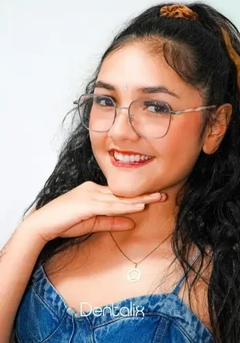 Paciente de Dentalix con gafas sonriendo tras su tratamiento de ortodoncia